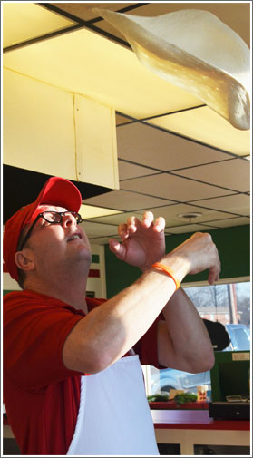 Picture of Dave Suiter tossing pizza dough in the air